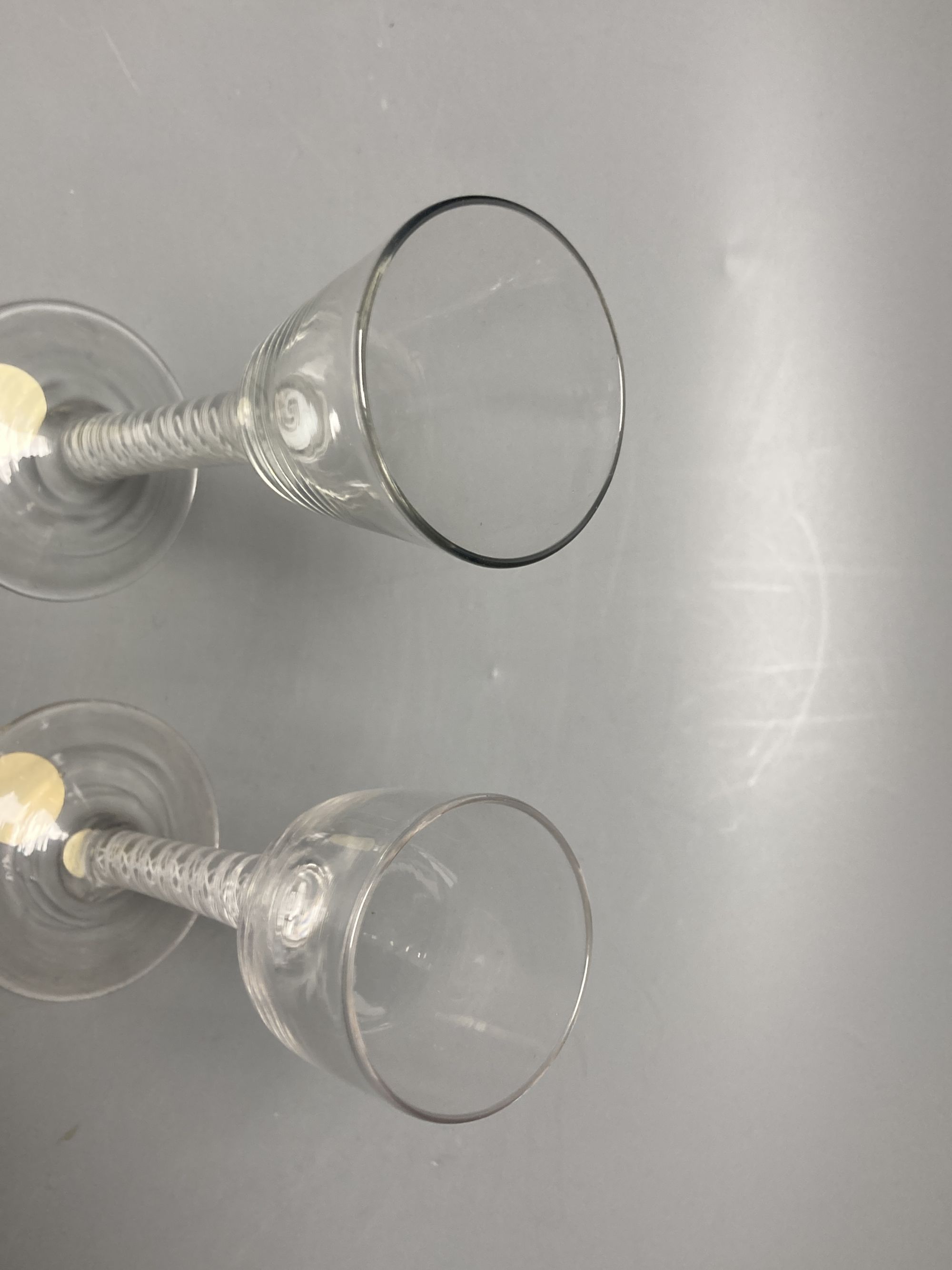 Two George III double series opaque twist stem cordial glasses, c.1765, with funnel and ogee bowls, 14.3cm and 13.6cm